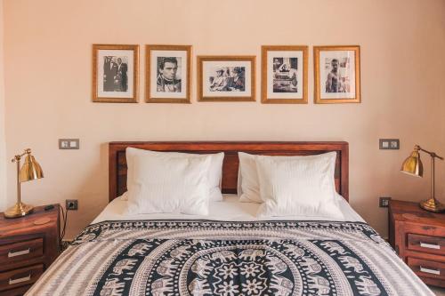 1 dormitorio con 1 cama con 4 cuadros en la pared en Shangri-La Fuerteventura, en Tefía