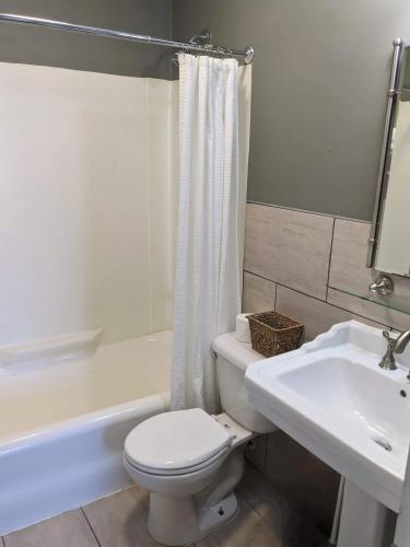 a white bathroom with a toilet and a sink at Chelsea Pub and Inn in Atlantic City