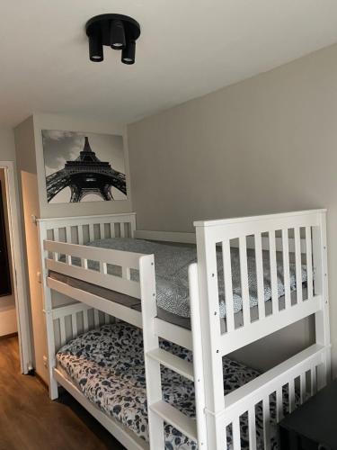a bedroom with two white bunk beds and a mirror at Feel at home at this Homeawayfromhome appt with a stunning water canal view and home gym in Ghent