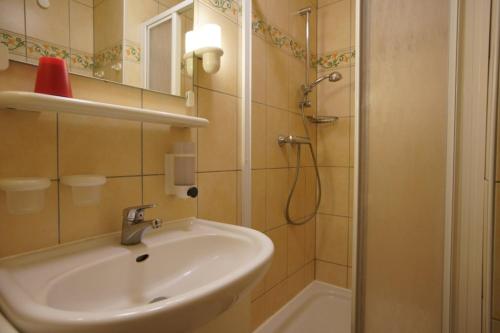 La salle de bains est pourvue d'un lavabo et d'une douche. dans l'établissement Strandliebe Borkum, à Borkum