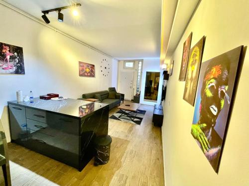a room with a desk and a living room with paintings at Cosy flat nearTaksim/Nişantaşi in Istanbul