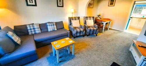 a living room with a couch and two chairs and a table at Tom's Place in Kirkcudbright