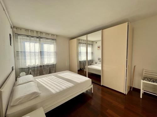 una camera da letto con un grande letto bianco e uno specchio di Beau Soleil ad Aosta