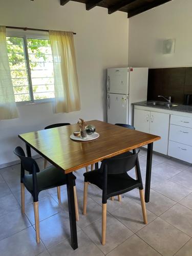 a kitchen with a wooden table and some chairs at Firenze Cabañas - Playa Chapadmalal in Chapadmalal