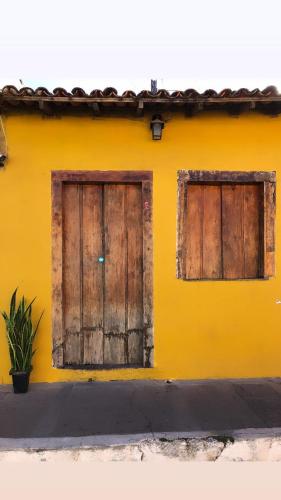 twee houten deuren op een geel gebouw bij Hostel Solar in Mucugê