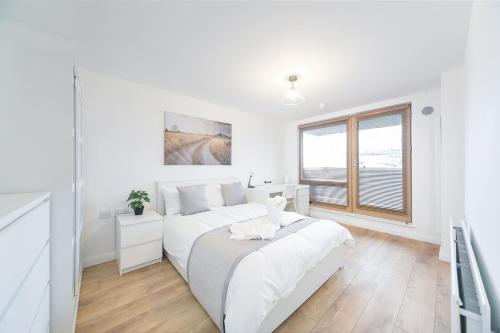 a white bedroom with a bed and a window at St Pancras Residence 1 BR Flat Sleeps 4 in London