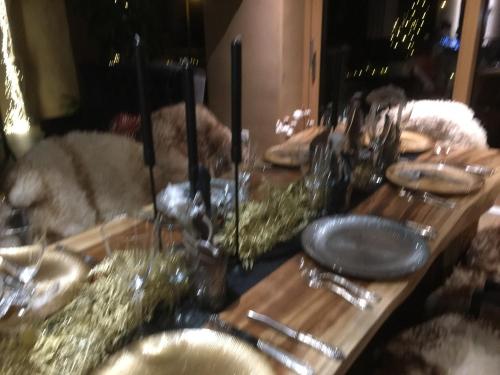 a long wooden table with plates and utensils on it at Green & Breakfast Chambre Satita in Niederpallen