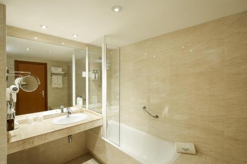 uma casa de banho com uma banheira, um lavatório e um chuveiro em Sercotel Cornellà Barcelona em Cornellà de Llobregat