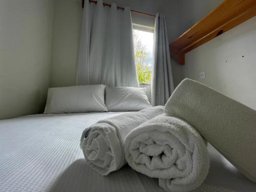 a bedroom with a bed with towels on it at Caraiva Recanto Pousada de Ferias in Caraíva