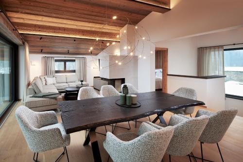 a dining room and living room with a table and chairs at Alpin Residenzen Eichenheim Aurach bei Kitzbühel by Alpina-Holiday in Aurach bei Kitzbuhel