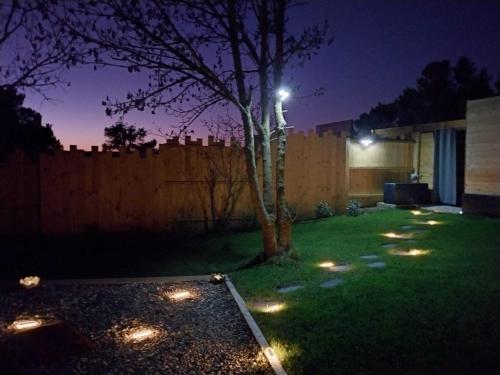 a yard with lights in the grass at night at Le Clos FMR Insolite - "F"anny Carcassonne in Malves-en-Minervois