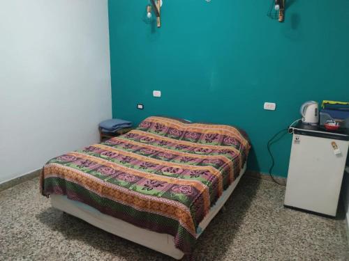 een bed in een kamer met een blauwe muur bij Complejo Berazategui in Villa D. Sobral