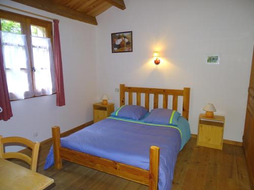 1 dormitorio con cama, mesa y ventana en Domaine du Mayne - Le Chene - Clévacances 2 Clés, en Blanquefort-sur-Briolance