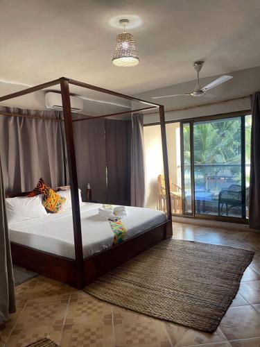 a bedroom with a canopy bed in a room at Afiki in Ankwanda