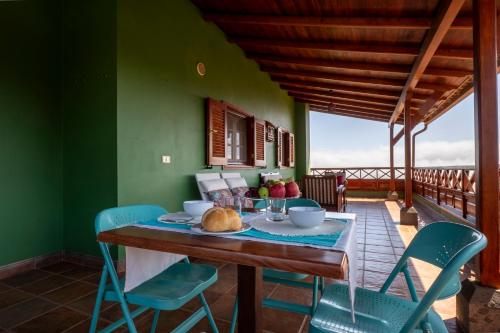 comedor con paredes verdes, mesa y sillas en Casa Rural Gran Canaria El Cañaveral, en Vega de San Mateo