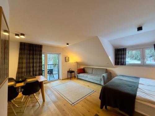 a bedroom with a bed and a desk and a couch at Apartmaji Kotnik in Kranjska Gora