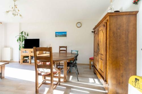 une salle à manger avec une table et des chaises en bois dans l'établissement Bel appartement à la montagne, à Séez