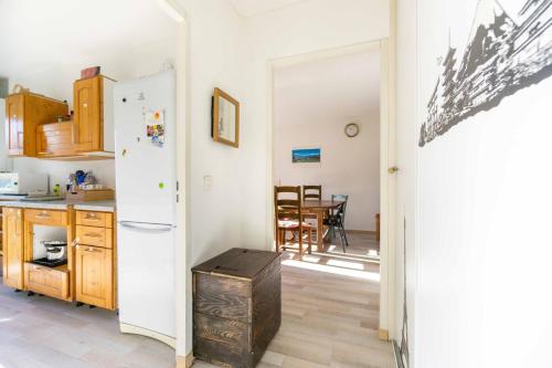 a kitchen with a white refrigerator and a table at Bel appartement à la montagne in Séez