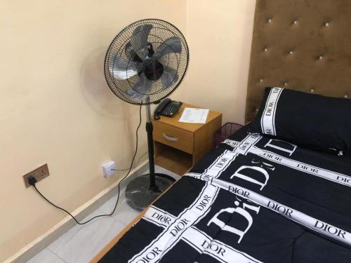 a bedroom with a fan next to a bed at MAVINIK'S (Ogun State) HOTEL, SUITES AND LOUNGE in Otta