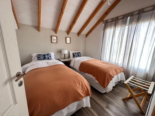 1 dormitorio con 2 camas y ventana en Patagonia Hikes Aparts en El Chaltén
