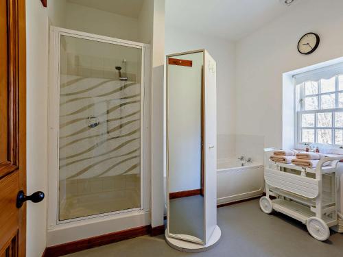 a bathroom with a walk in shower and a tub at 1 Bed in Alness CA015 in Boath