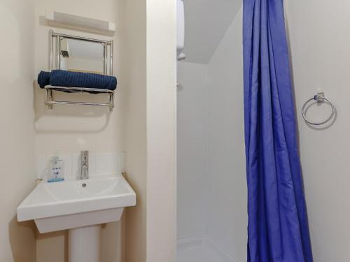 La salle de bains blanche est pourvue d'un lavabo et d'une douche. dans l'établissement 1 Bed in Badachro CA357, à Strath