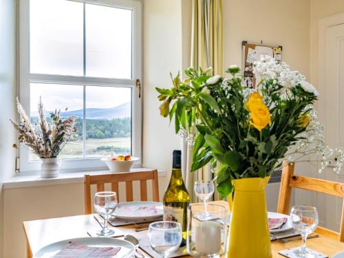 a dining room table with a yellow vase with flowers at 3 bed in Carron CA227 in Carron