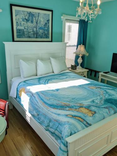 a blue bedroom with a bed with a white headboard at Chelsea Pub and Inn in Atlantic City