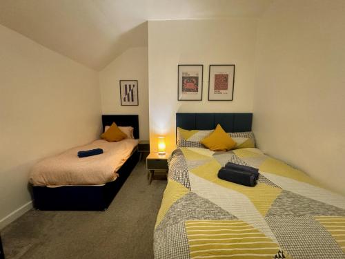 sypialnia z 2 łóżkami i lampką w obiekcie Space For Groups, 10 mins from centre with parking! w Cardiff
