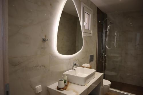 a bathroom with a sink and a mirror and a shower at Merelia Luxury Guesthouse in Haraki