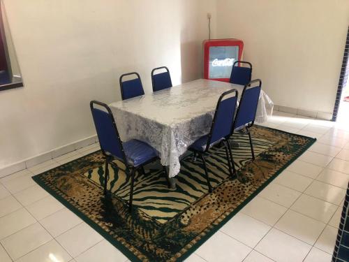 uma mesa de jantar com cadeiras azuis e uma máquina vermelha em Easah Homestay Malacca em Malaca