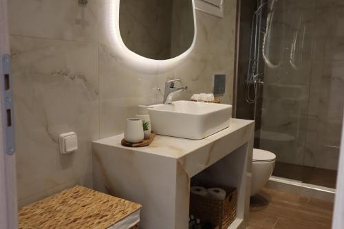 a bathroom with a sink and a mirror and a toilet at Merelia Luxury Guesthouse in Haraki