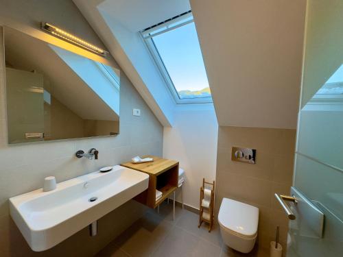 a bathroom with a sink and a skylight at Apartmaji Kotnik in Kranjska Gora
