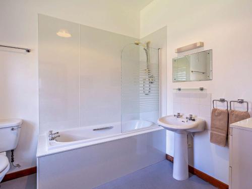 a white bathroom with a tub and a sink at 1 Bed in Alness CA232 in Boath
