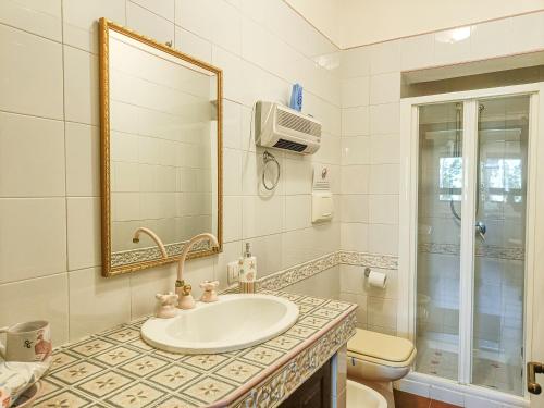 a bathroom with a sink and a toilet and a mirror at Villa Alice e Silvia - Chia in Chia