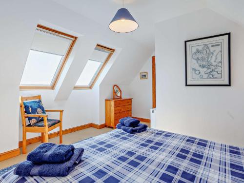 um quarto com uma cama azul e uma cadeira em 3 Bed in Ardvasar CA071 em Aird of Sleat
