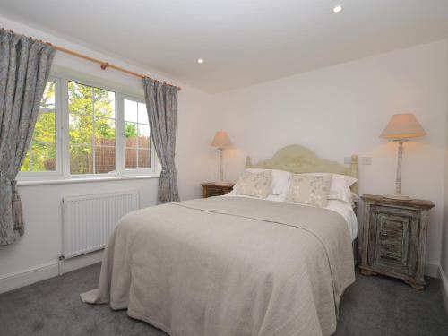 een witte slaapkamer met een bed en een raam bij 1 Bed in Taunton 75135 in Isle Brewers