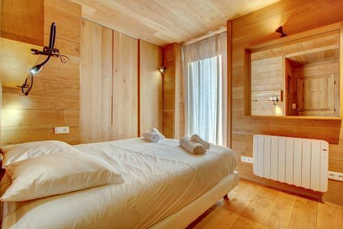 a bedroom with a large white bed with a mirror at AUBERGE 1 in Morzine