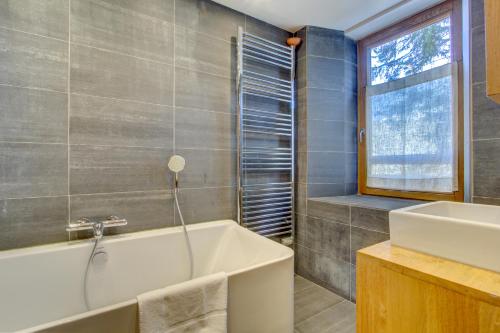 a bathroom with a tub and a sink at AUBERGE 1 in Morzine