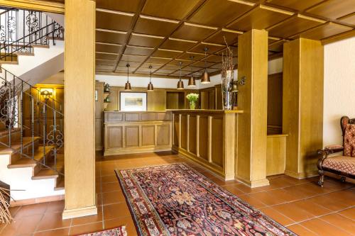 a living room with a staircase and a rug at Flair-Hotel Zum Benediktiner in Schwarzach am Main