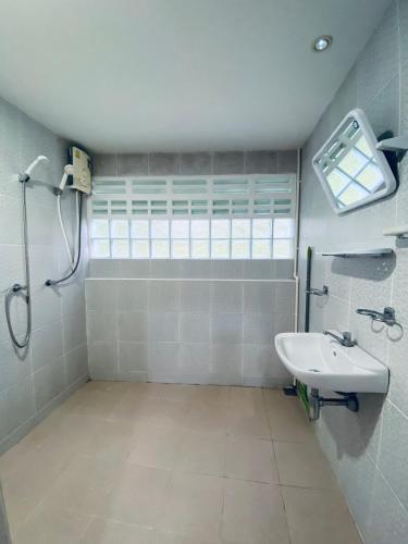 a bathroom with a sink and a shower at Elephant Sports Bar and Accommodation in Phuket