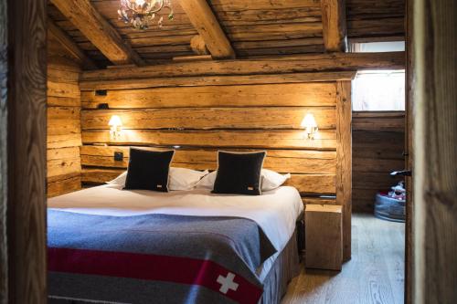 ein Schlafzimmer mit einem Bett in einem Blockhaus in der Unterkunft Les Chalets PVG in La Clusaz
