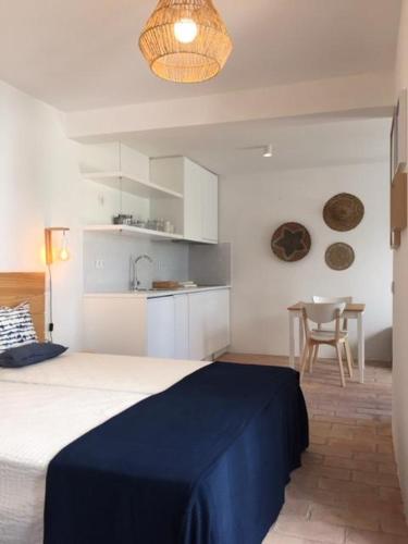a bedroom with a bed and a kitchen with a table at Hoso Loft 24 Beach House in Costa da Caparica
