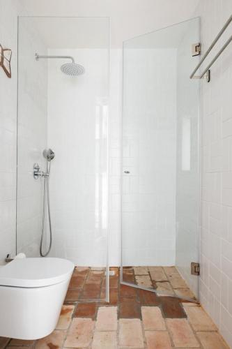 a bathroom with a tub and a shower with a bath tub at Hoso Loft 24 Beach House in Costa da Caparica
