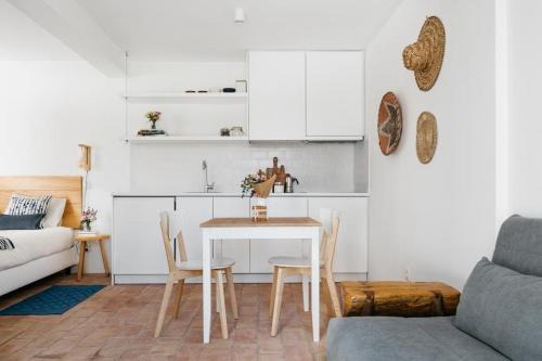 cocina y sala de estar con mesa y sillas en Hoso Loft 24 Beach House en Costa da Caparica