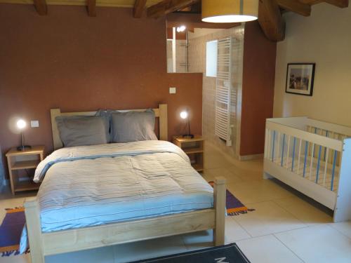 ein Schlafzimmer mit einem großen Bett in einem Zimmer in der Unterkunft Domaine du Mayne - La Ferme - Clévacances 3 clés in Blanquefort-sur-Briolance