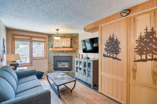 a living room with a blue couch and a fireplace at Ski-InandSki-Out Winter Park Condo with Mountain Views in Winter Park