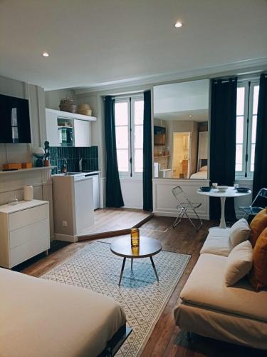 un salon avec un canapé et une table et une cuisine dans l'établissement Yukos-Studio Cosy-(Hypercentre), à Rennes