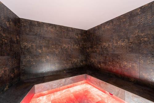an empty room with rusty walls and a red floor at Hotel Majon Miramonti in Canazei