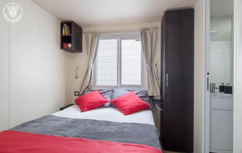 a bedroom with a bed with two red pillows at Centro Turistico San Nicola in Peschici